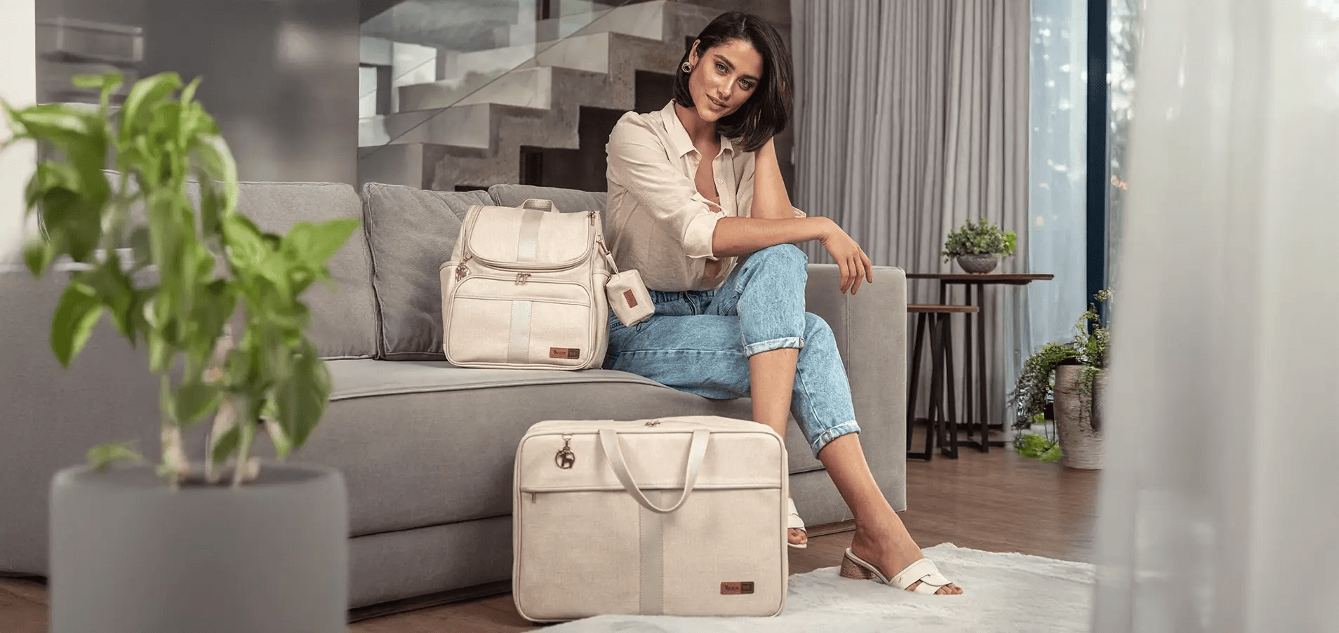 Mulher com mochila e mala maternidade Alce em ambiente neutro